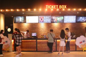 Những cặp đôi đang đứng trước quầy để mua vé xem phim